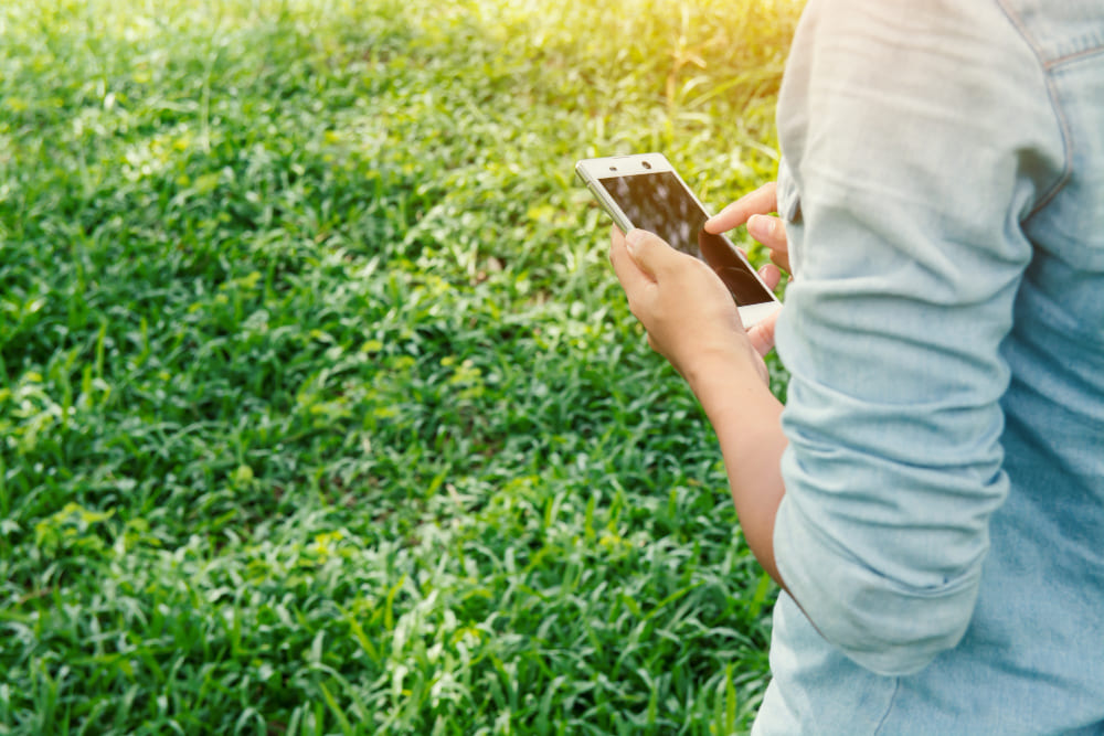 Persona usando celular en campo rural