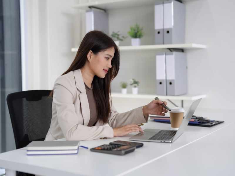 mujer organizándose frente a una computadora para tener sus entregas a tiempo