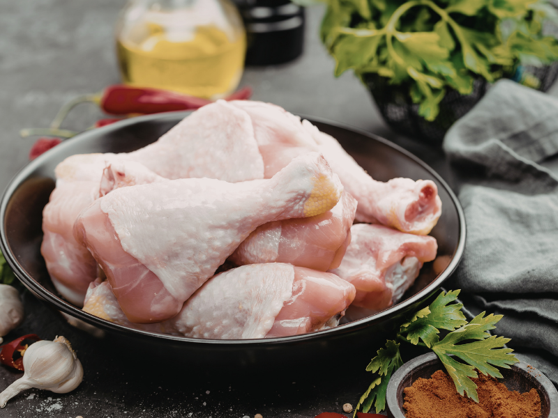 Tazón con piezas de pollo crudas (muslos y piernas) listas para cocinar en caldo o guiso.